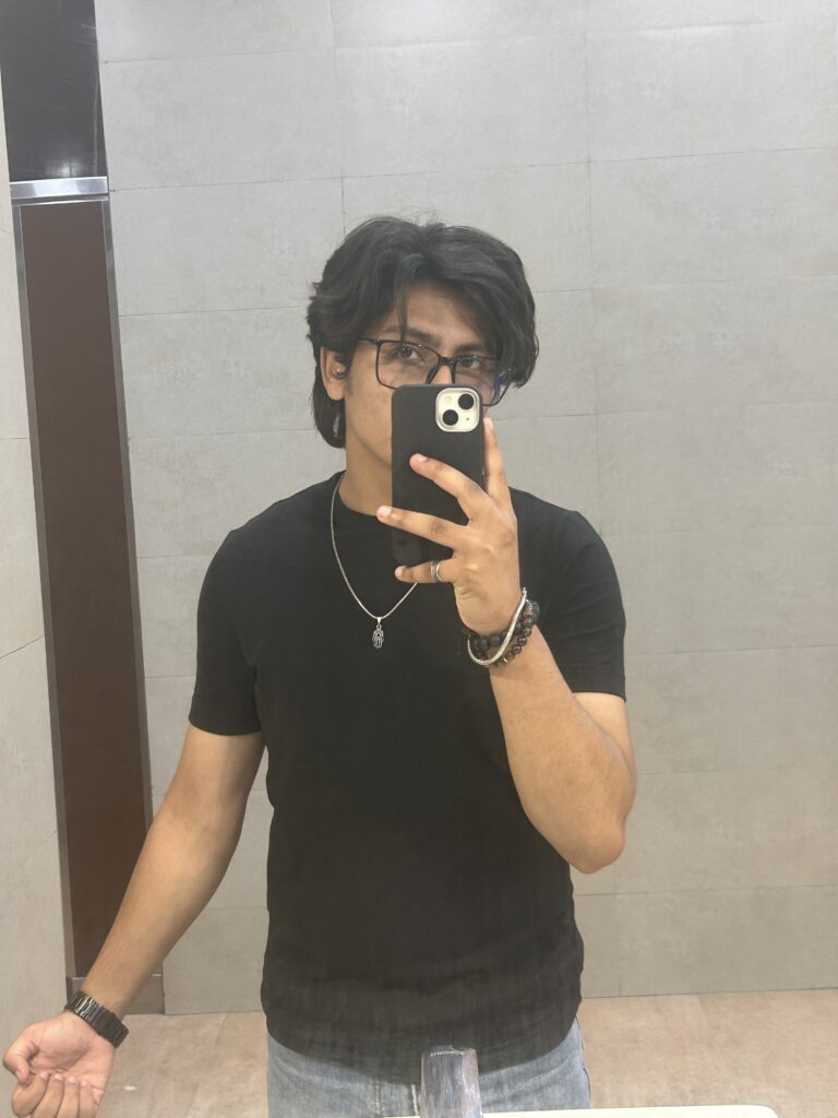 Mirror selfie of a young man in black t-shirt and denim showcasing personal style – Kapilverse Blog